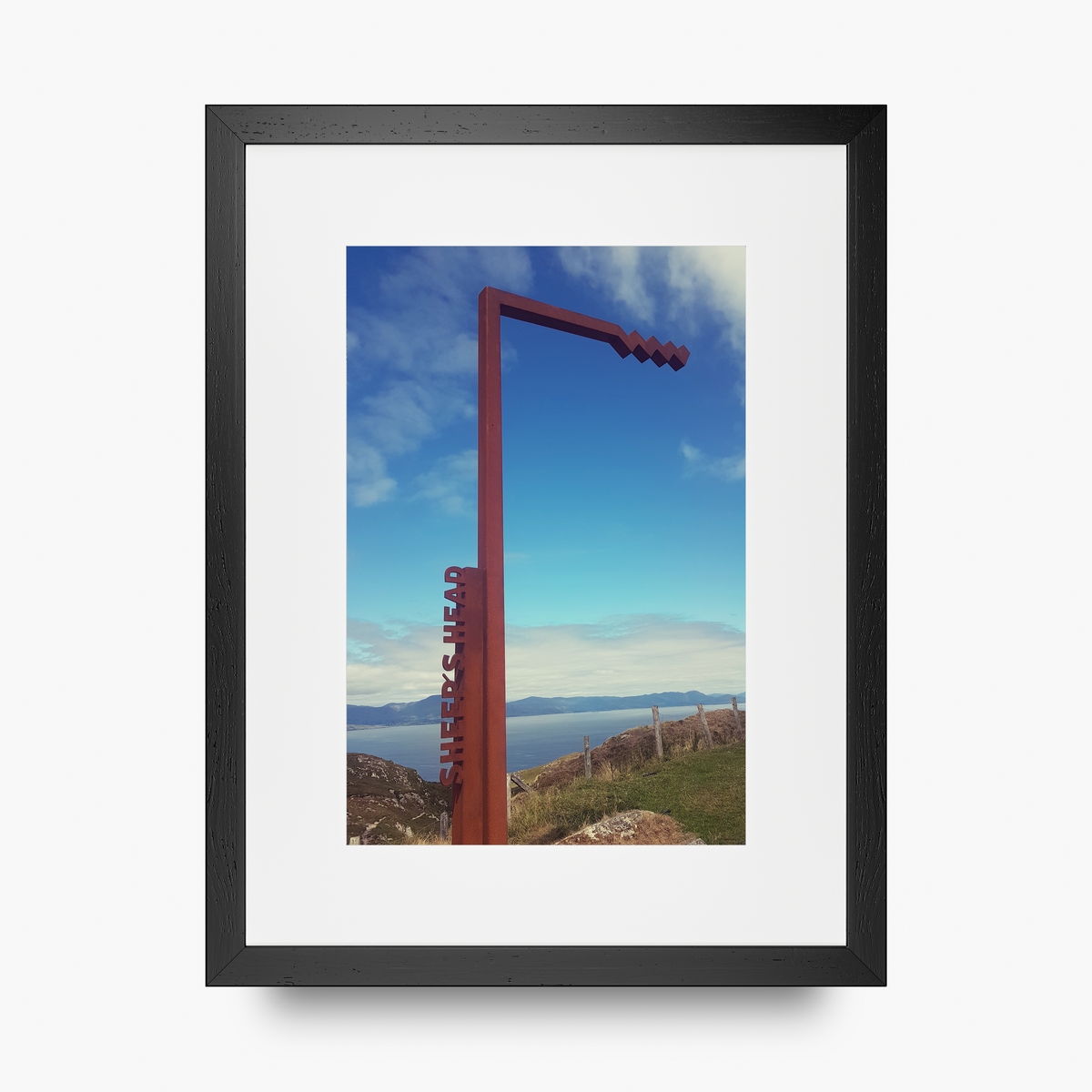 A portrait shaped frame print in a black frame featuring The Sheep's Head stop on the Wild Atlantic Way