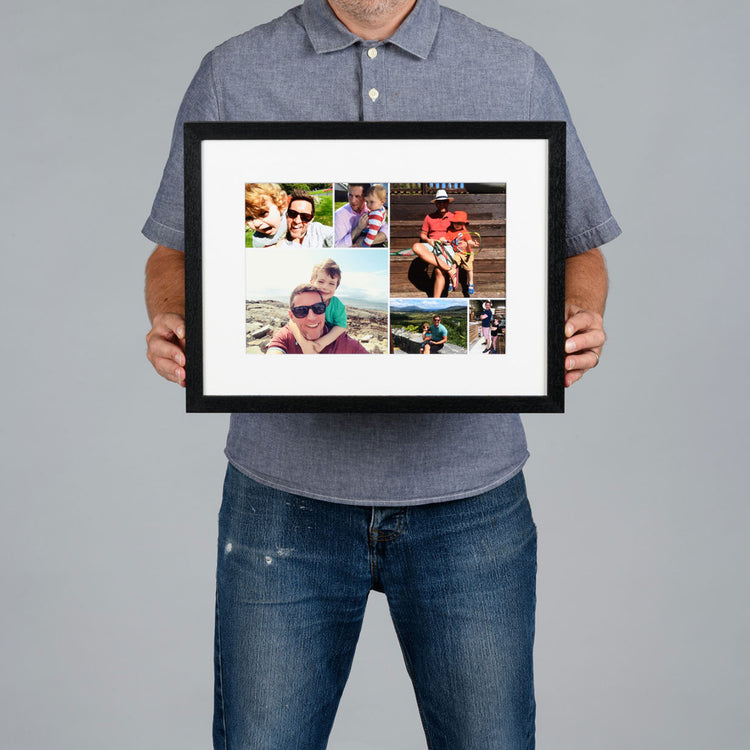 A man holds a black-framed custom photo collage print with a white mat against a solid gray background. The image is 30x20cm and the frame is 44x34cm. 